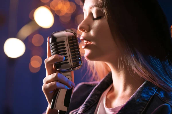 Mooie vrouwelijke zangeres met microfoon op het podium — Stockfoto