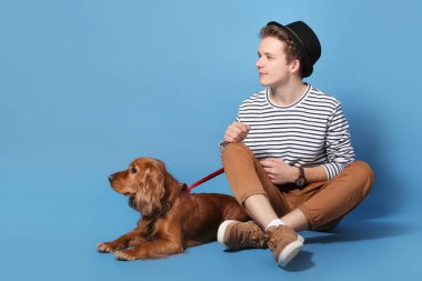 Renkli arka planda sevimli köpek ile Genç çocuk