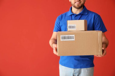 Renkli arka plan üzerinde kutuları ile Yakışıklı teslimat adam