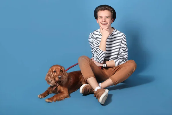 Έφηβος αγόρι με χαριτωμένο σκύλο στο χρώμα φόντο — Φωτογραφία Αρχείου
