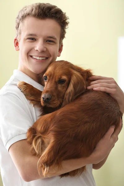 Хлопчик-підліток з милою собакою на кольоровому фоні — стокове фото
