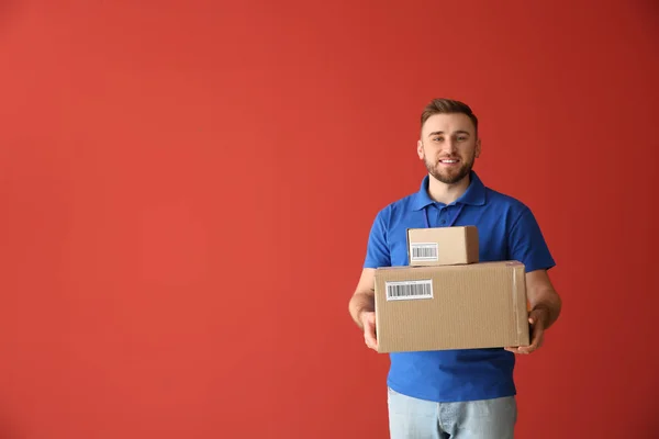 Przystojny człowiek dostawy z pudełka na kolorowym tle — Zdjęcie stockowe