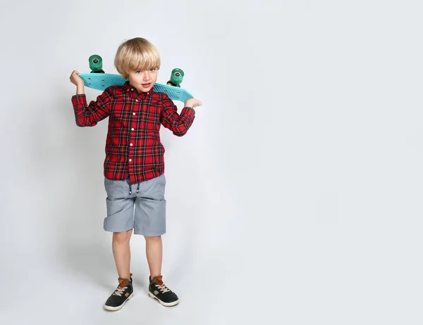 Lindo niño pequeño con monopatín sobre fondo claro — Foto de Stock