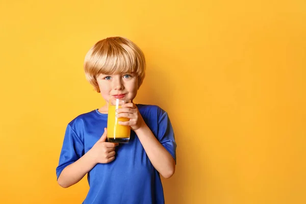 Cute Little Boy ze szklanką świeżego soku na kolorowym tle — Zdjęcie stockowe