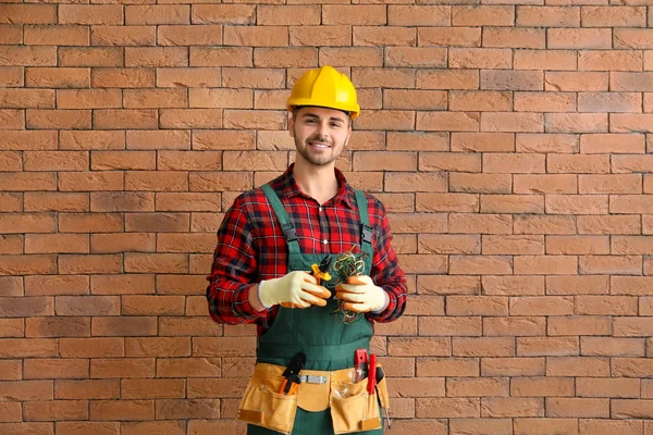 Hombre electricista cerca de la pared de ladrillo — Foto de Stock