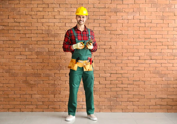 Male electrician near brick wall — Stock Photo, Image