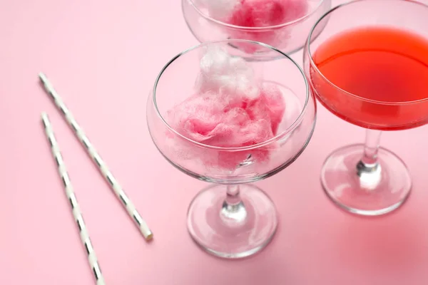Glasses with tasty cotton candy and cocktail on color background — Stock Photo, Image
