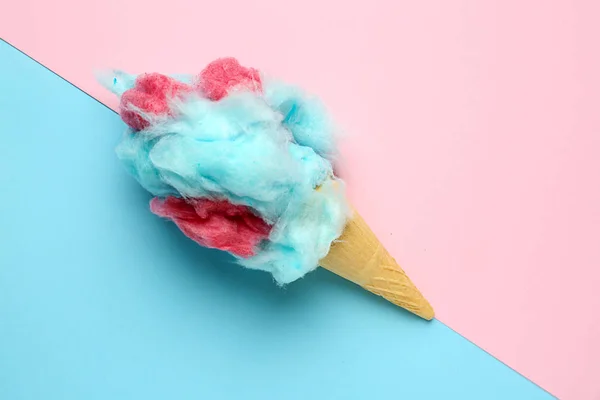 Wafer cone with tasty cotton candy on color background — Stock Photo, Image
