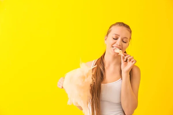 Schöne Frau mit Zuckerwatte auf farbigem Hintergrund — Stockfoto