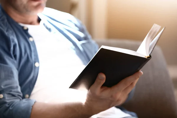 Knappe volwassen man lezen boek thuis, close-up — Stockfoto