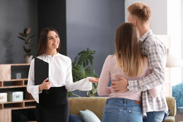 Real estate agent showing young couple a new house — Stock Photo, Image
