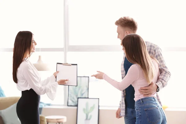 Real estate agent working with young couple — Stock Photo, Image