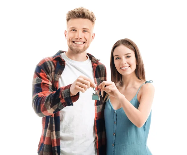 Young couple with key from their new house on white background — Stock Photo, Image