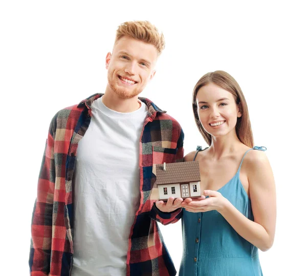 Young couple with house model on white background