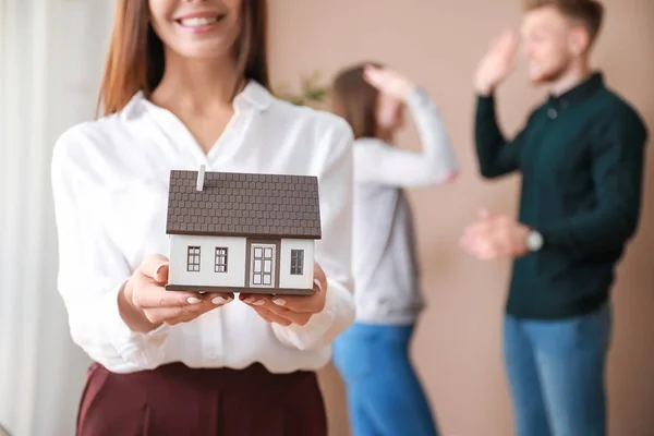 Kvinna fastighetsmäklare med hus modell inomhus — Stockfoto