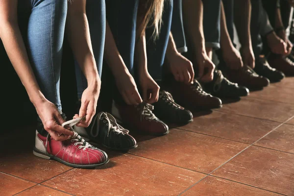 Przyjaciele zmieniają buty przed rozpoczęciem gry w kręgle w klubie — Zdjęcie stockowe