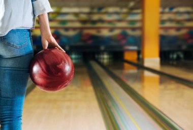 Kulüpte bowling oynayan genç bir kadın.
