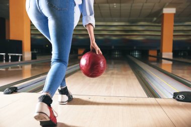 Kulüpte bowling oynayan genç bir kadın.