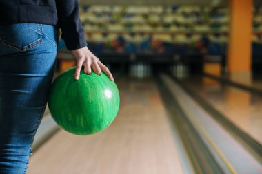 Kulüpte bowling oynayan genç bir kadın.