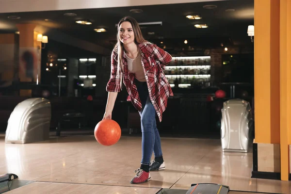 Fiatal nő játszik bowling klubban — Stock Fotó