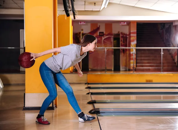 Young woman playing bowling in club — Stock Photo, Image