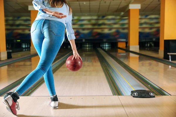 Young woman playing bowling in club — Stock Photo, Image