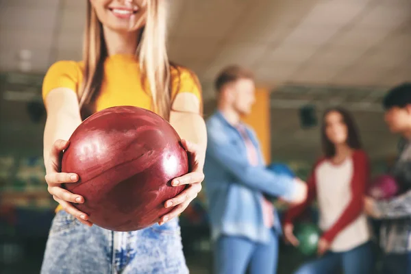 Young woman with friends in bowling club — Stock Photo, Image