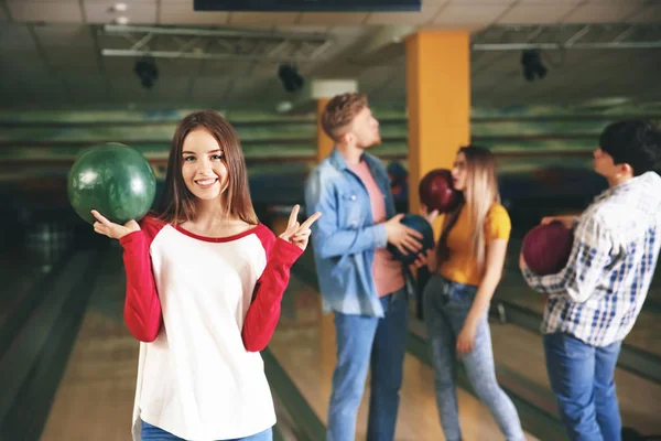 Young woman with friends in bowling club — Stock Photo, Image