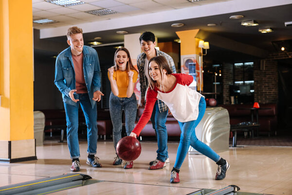 Friends playing bowling in club