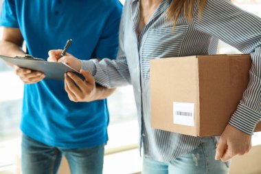 Woman signing documents to confirm receiving of order from delivery company