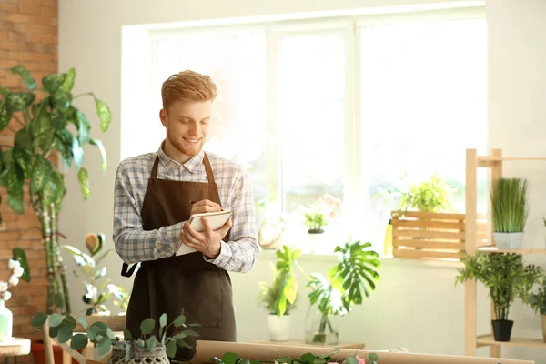Young male florist working in shop — Stock Photo, Image