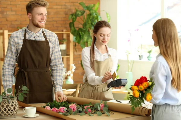 Kvinna betalar för beställning i blomsteraffär — Stockfoto