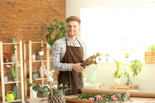 Floristería masculina joven trabajando en la tienda — Foto de Stock