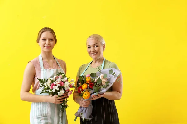 Fleuristes féminines avec bouquets sur fond de couleur — Photo