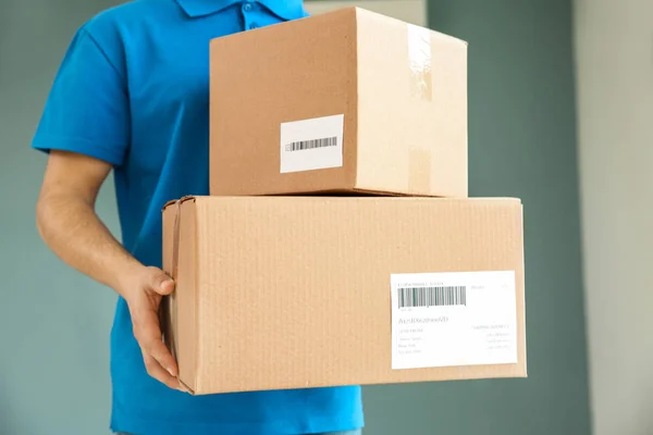 Delivery man with boxes indoors — Stock Photo, Image