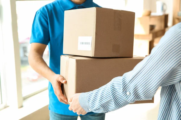 Woman receiving boxes from delivery man — Stock Photo, Image