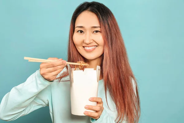 Asian kobieta jedzenie pyszne chińskie jedzenie na kolor tło — Zdjęcie stockowe