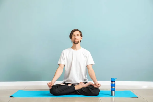 Sporty man practicing yoga indoors — Stock Photo, Image