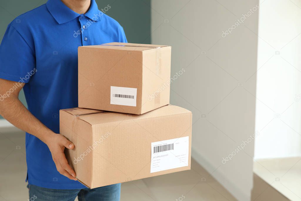 Delivery man with boxes indoors