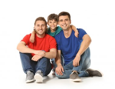 Beyaz arka planda evlatlık çocuğu olan mutlu eşcinsel çift
