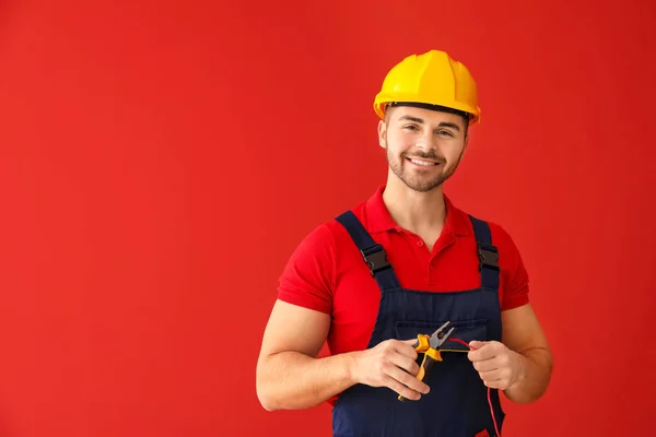 Male electrician on color background — Stock Photo, Image