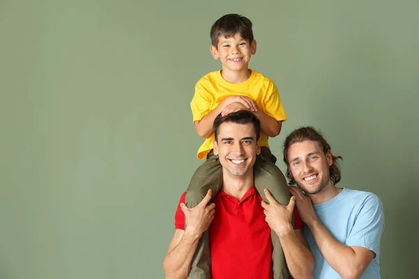 Feliz pareja gay con adoptado niño en color fondo —  Fotos de Stock