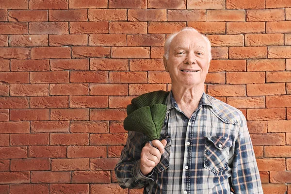 Retrato de anciano contra pared de ladrillo — Foto de Stock