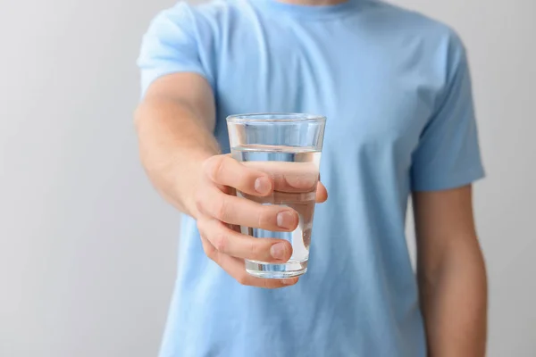 Man with glass of fresh water on light background, closeup — Stock Photo, Image