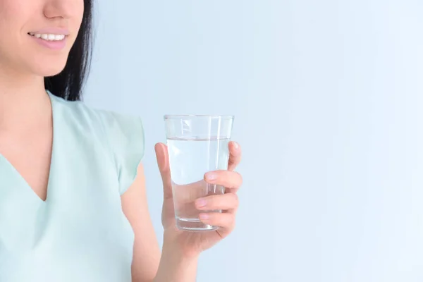 Woman with glass of fresh water on light background — Stock Photo, Image