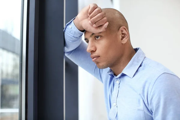 Handsome African-American man near window in office — Stock Photo, Image