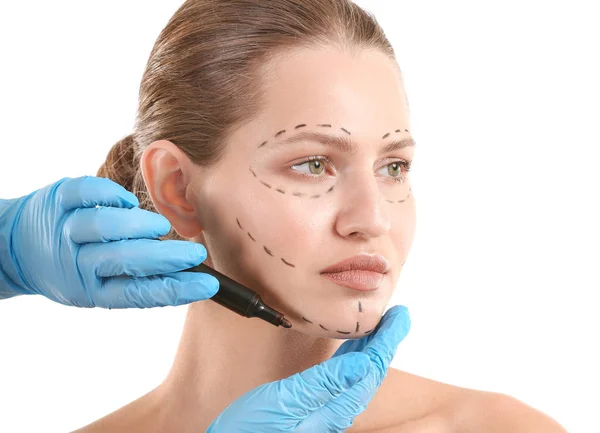 Cirujano plástico que aplica la marca en la cara femenina sobre fondo blanco — Foto de Stock