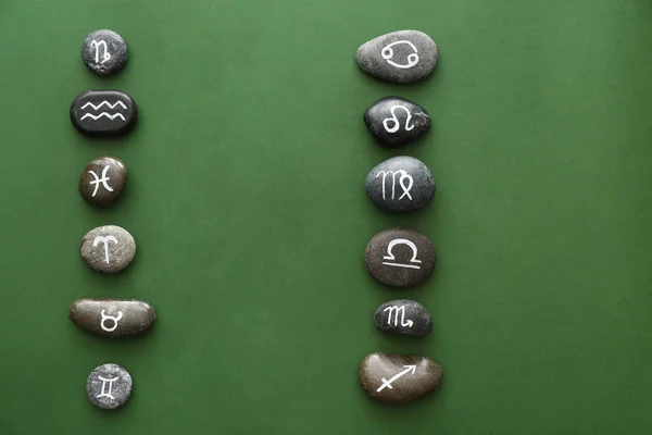 Piedras con signos del zodíaco pintados sobre fondo de color — Foto de Stock