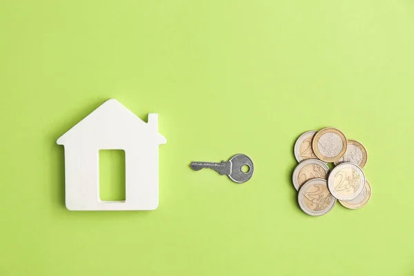 Figure of house, key and money on color background — Stock Photo, Image