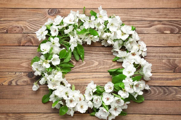 Beautiful flowers and leaves on wooden table — Stock Photo, Image